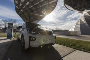 A BMW i3 plug-in automobile, produced by Bayerische Motoren Werke AG , sits beside an electric charging station outside the BMW World showroom in Munich, Germany, on Tuesday, Jan. 26, 2016. BMW is at risk of losing its lead in the luxury car market this year to Mercedes-Benz after reporting the slowest sales growth since 2009 while its German arch-rival charged ahead with a fresher lineup and surging demand in China. Photographer: Martin Leissl/Bloomberg