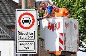 Traffic signs which ban diesel cars are installed by workers at the Max-Brauer Allee in downtown Hamburg, Germany May 16, 2018. REUTERS/Fabian Bimmer