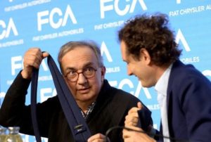 Серджо Маркионе държи вратовръзка пред председателя на Fiat Chrysler Automobiles Джон Елкан, след представянето на петгодишния план на автомобилния производител на тестовата писта Balocco в Торино, Италия, на 1 юни. Сн.: BLOOMBERG