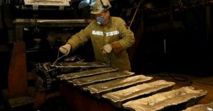 Работник контролира формоването на алуминиеви блокове на конвейерна лента в леярния цех на алуминиевия завод Русал Красноярск в Красноярск
