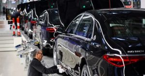 Работник прикрепя част към автомобил Mercedes-Maybach на производствена линия на "Factory 56", едно от най-модерните халета за сглобяване на електрически и конвенционални автомобили в света на германския автомобилен производител Mercedes-Benz, в Зинделфинген близо до Щутгарт, Германия