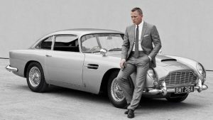 Aston Martin DB5 от 1964 г. се появява в „Thunderball“ (Операция „Мълния“) и „Goldfinger“ (Голдфингър), превръщайки се в емблематичния автомобил на Джеймс Бонд.Оборудван с джаджи като картечници, въртящи се номера и катапултираща седалка, този 4-литров спортен автомобил затвърждава легендарния си статус в шпионската поредица. 