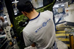 Логото на Stellantis се вижда върху тениската на служител, който работи на автомобилната монтажна линия за автомобили Peugeot 308 и Peugeot 408 във фабриката на Stellantis в Мюлуз, Източна Франция, 2 юни 2026 г.